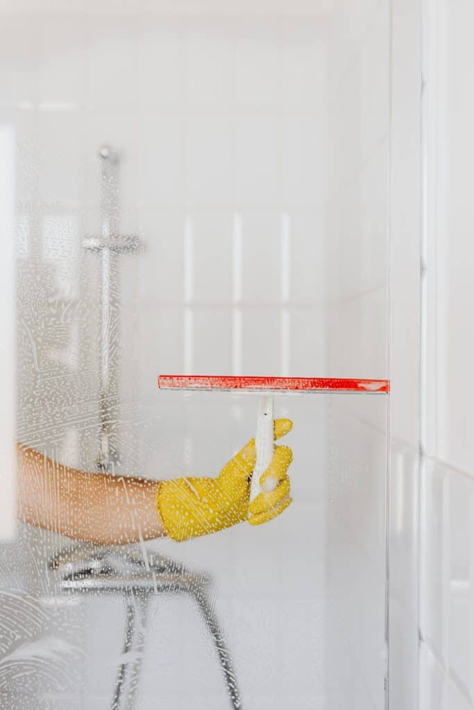 Reinigungsschaum wird von einer Glasfläche abgezogen